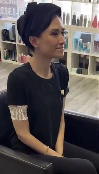 Jess sits in hair salon chair with a towel wrapped around her head.
